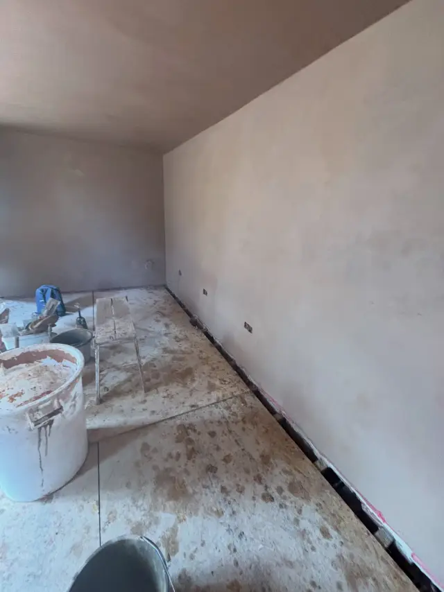 Teal-accented plaster in narrow hallway